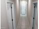 Clean hallway featuring neutral tones, white doors, and neutral tile flooring at 17353 W Via De Luna Dr, Surprise, AZ 85387