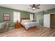 Spacious primary bedroom with a ceiling fan, shutters and wood-look flooring at 17637 N Goldwater Dr, Surprise, AZ 85374