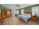 Spacious primary bedroom with a ceiling fan, shutters and wood-look flooring at 17637 N Goldwater Dr, Surprise, AZ 85374