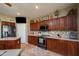 Warm kitchen featuring updated appliances, stylish backsplash, and cherry wood cabinetry at 17637 N Goldwater Dr, Surprise, AZ 85374
