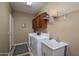 Functional laundry room with washer, dryer, utility sink, and storage cabinets at 17637 N Goldwater Dr, Surprise, AZ 85374