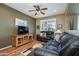 Cozy living room featuring a ceiling fan, wood floors, and comfortable leather seating at 17637 N Goldwater Dr, Surprise, AZ 85374
