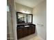 Bathroom with a dark wood vanity, granite countertop, framed mirror and tiled floor at 18515 N 94Th St, Scottsdale, AZ 85255