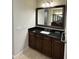 Bathroom featuring a dark wood vanity with granite countertop, a framed mirror and tiled floor at 18515 N 94Th St, Scottsdale, AZ 85255