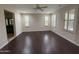 Bright bedroom featuring hardwood floors, ceiling fan, and three windows with plantation shutters at 18515 N 94Th St, Scottsdale, AZ 85255