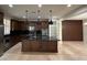 The renovated kitchen has sleek dark cabinetry, stainless appliances, and a central island at 18515 N 94Th St, Scottsdale, AZ 85255