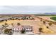 Wide aerial shot of a suburban neighborhood with open fields and mountain views at 20358 N Valencia N Dr, Maricopa, AZ 85138