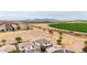 Scenic aerial view of a neighborhood next to green fields and mountains at 20358 N Valencia N Dr, Maricopa, AZ 85138