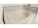 Modern white bathtub with marble-look tile surround and chrome hardware at 20358 N Valencia N Dr, Maricopa, AZ 85138
