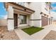 Inviting entryway with rock landscaping, green turf, and a three car garage at 20358 N Valencia N Dr, Maricopa, AZ 85138