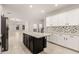 Bright kitchen features a large island, white cabinetry, stone countertops, and mosaic backsplash at 20358 N Valencia N Dr, Maricopa, AZ 85138