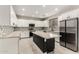 Modern kitchen with white cabinets, mosaic backsplash, stainless appliances, and black island at 20358 N Valencia N Dr, Maricopa, AZ 85138