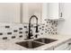 Close-up of the kitchen sink featuring a modern matte black faucet, stainless steel basin, and stone countertop at 20358 N Valencia N Dr, Maricopa, AZ 85138