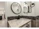Close up of a half bath featuring modern mirror, stone countertop, sink, and a decorative accent tile at 20358 N Valencia N Dr, Maricopa, AZ 85138