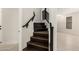 Staircase with dark wood steps and dark stained banister with white risers at 20358 N Valencia N Dr, Maricopa, AZ 85138