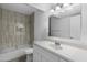 Bathroom with tub, tiled shower, white vanity and modern fixtures at 2220 W Dora St # 129, Mesa, AZ 85201