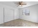 Bedroom features a ceiling fan, tile flooring, closet, and window with blinds at 2220 W Dora St # 129, Mesa, AZ 85201