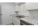 Bright kitchen featuring granite countertops, stainless steel sink, and white cabinets at 2220 W Dora St # 129, Mesa, AZ 85201