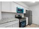 Well-equipped kitchen with white cabinets, stainless steel appliances and granite countertops at 2220 W Dora St # 129, Mesa, AZ 85201