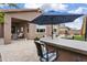 Inviting backyard bar area with tiled patio, comfortable seating, and a stylish bar, perfect for entertaining guests at 24757 N 175 Dr, Surprise, AZ 85387
