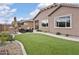Lush backyard featuring artificial turf, a stone patio, and comfortable outdoor seating under the bright, sunny sky at 24757 N 175 Dr, Surprise, AZ 85387