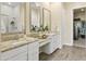 Bright bathroom with dual vanities, granite countertops, framed mirrors and a glass-enclosed shower at 24757 N 175 Dr, Surprise, AZ 85387