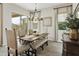 Sunlit dining area featuring stylish table setting, elegant chandelier, and sliding glass doors to patio at 24757 N 175 Dr, Surprise, AZ 85387