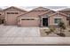 Charming single-story home showcasing a three-car garage, stone accents, and desert landscaping at 24757 N 175 Dr, Surprise, AZ 85387
