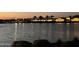 A tranquil nighttime view of community buildings reflected in the shimmering lake at 24757 N 175 Dr, Surprise, AZ 85387