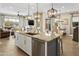 Beautiful kitchen with granite counters, stainless steel appliances, and open floor plan to dining and living room at 24757 N 175 Dr, Surprise, AZ 85387