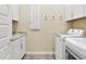 Functional laundry room with washer, dryer, storage cabinets, and granite countertop for folding clothes at 24757 N 175 Dr, Surprise, AZ 85387