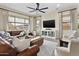 Spacious living room with a large leather sofa, modern décor, and a ceiling fan at 24757 N 175 Dr, Surprise, AZ 85387
