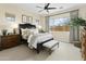 Inviting main bedroom with a large window, dark wood accents, soft bedding, and stylish furnishings at 24757 N 175 Dr, Surprise, AZ 85387