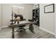 Well-lit home office with a wooden desk, office chair, bookshelf, and view from the window at 24757 N 175 Dr, Surprise, AZ 85387