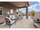 Covered outdoor patio with comfortable seating, outdoor grill, and elegant water feature at 24757 N 175 Dr, Surprise, AZ 85387