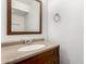 This is a close up of a bathroom sink with a dark wood frame mirror and a beige quartz countertop at 2875 W Highland St # 1213, Chandler, AZ 85224