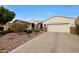 Lovely home exterior with desert landscaping and a long driveway leading to the garage at 3134 N 145Th Ave, Goodyear, AZ 85395