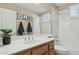 Bathroom with a single sink vanity, shower-tub, and tiled flooring, adorned with framed art at 3362 N 159Th Ave, Goodyear, AZ 85395