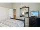 Comfortable bedroom features a mirrored wall, closet, dresser and a TV at 3362 N 159Th Ave, Goodyear, AZ 85395
