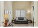 Comfortable sitting room with neutral walls, a couch with pillows, and a floor lamp at 3362 N 159Th Ave, Goodyear, AZ 85395