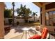 Covered back patio with a small table and chair set overlooking the backyard at 3631 S Greythorne S Way, Chandler, AZ 85248