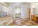 Large bathroom with a soaking tub, tile floor, and an abundance of natural light at 3631 S Greythorne S Way, Chandler, AZ 85248
