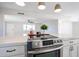 Modern stainless steel oven with white cabinetry and quartz countertops in a bright, open kitchen, flowing into the living room at 38234 N 15Th Ave, Phoenix, AZ 85086