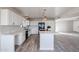 Bright kitchen featuring an island with quartz countertops, white cabinets, and stainless steel appliances, flowing into an open living space at 38234 N 15Th Ave, Phoenix, AZ 85086