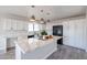 Well-lit kitchen boasts white cabinetry, quartz countertops, a spacious center island, modern pendant lighting and stainless appliances at 38234 N 15Th Ave, Phoenix, AZ 85086