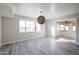 Spacious living room featuring neutral walls, tile flooring, a large window, and a decorative woven pendant light fixture at 38234 N 15Th Ave, Phoenix, AZ 85086