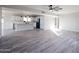 Open-concept living area featuring wood-look tiled floors flowing into the kitchen with white cabinets at 38234 N 15Th Ave, Phoenix, AZ 85086