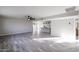 Spacious living area featuring wood-look tiled floors, ceiling fan, and a view into the kitchen at 38234 N 15Th Ave, Phoenix, AZ 85086