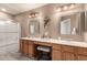 Bright bathroom featuring dual sinks, vanity with a chair and shower with a glass enclosure at 4122 E Jojoba Rd, Phoenix, AZ 85044