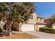 View of the home from the street, featuring a two-car garage and mature landscaping at 4122 E Jojoba Rd, Phoenix, AZ 85044